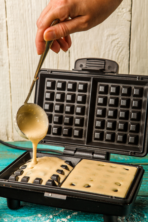 Making wafers at home. Pouring the dough into the waffle ironの写真素材