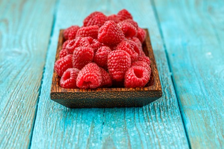 Fresh raspberry in a wooden plate