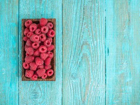 Fresh raspberry in a wooden plate. Photo with copyspaceの写真素材