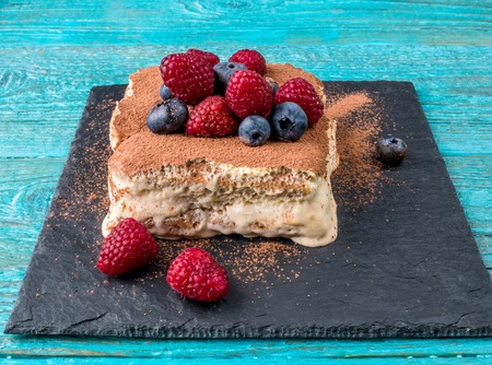 Tiramisu cake with raspberries and blueberries. Homemade tiramisu dessertの写真素材