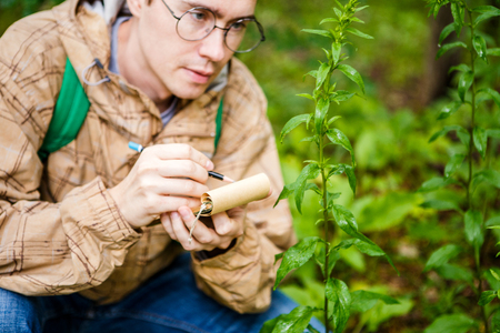 Photo of male biologist in glasses with notepad