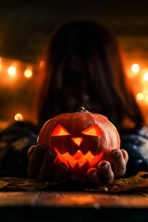 Photo of witch with long hair holding pumpkinの写真素材