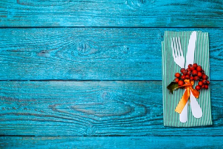 Photo of fork and knife on napkin on wooden background.