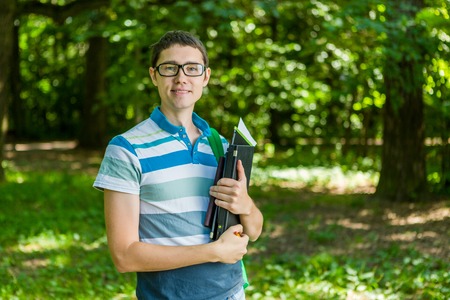 Photo of student wearing glasses with laptop, booksの写真素材