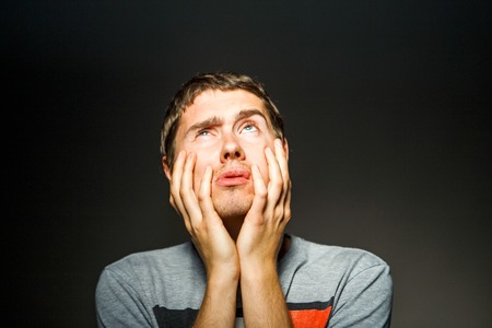 Photo of man in T-shirt with hands on chinの写真素材