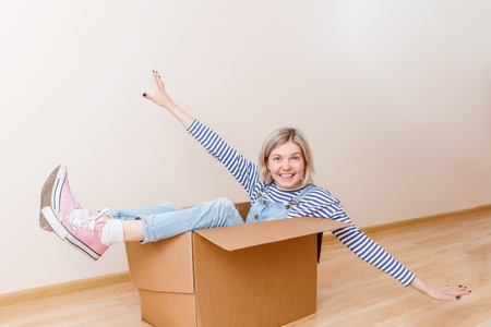 Photo of young woman sitting in cardboard boxの写真素材
