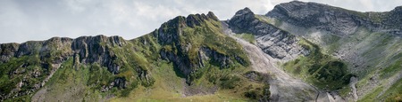 Photo of mountain slopes with vegetation and cloudy sky