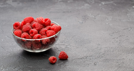 Photo of raspberries in transparent glass cup