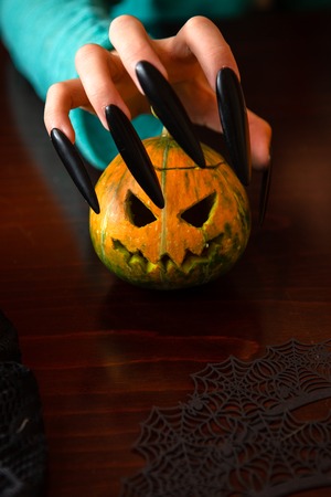 Image of mans hands with pumpkin jack sitting at wooden tableの写真素材