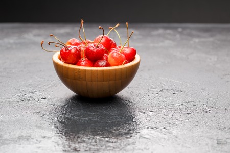 Photo of red cherry in wooden cupの写真素材