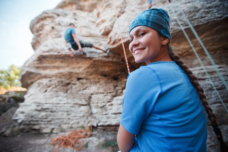 Photo of smiling woman rock climber on background of cliffの写真素材