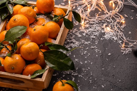 Image of tangerines in wooden box with burning garlandの写真素材