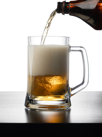 Frosty mug of light beer on wood tableの写真素材