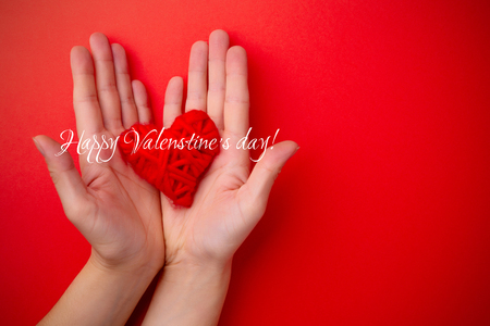 Hands hold red heart on red backgroundの写真素材