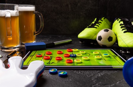 Image of two mugs of foam beer, table football, ball, rattle toyの写真素材