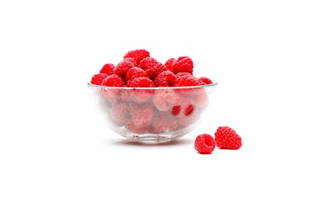 Image of green raspberry in glass cup on empty white