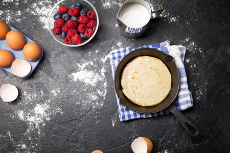 Photo on top of eggs, milk, flour, berries on black table.の写真素材