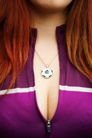 Beautiful female bust with a pendant in the form of a soccer ball.の写真素材