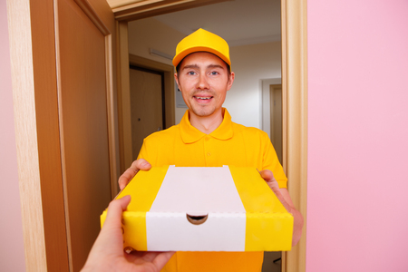 Photo of courier man with pizza box in hands .の写真素材