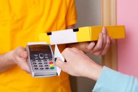 Woman pays for pizza credit card to courier via pin pad