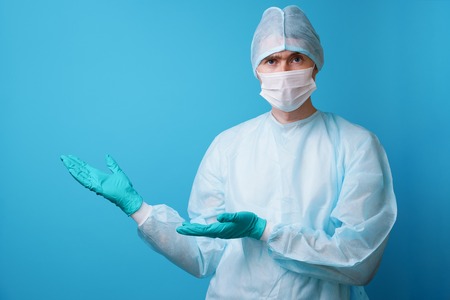 Surgeon in sterile blue uniform, medical gloves and maskの写真素材