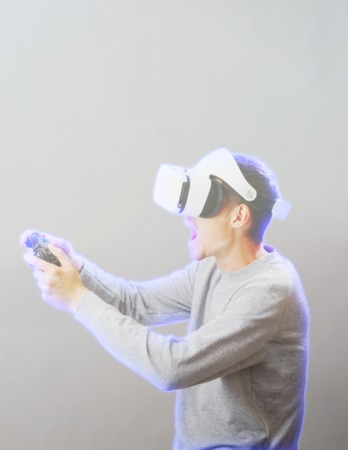 Man with virtual reality headset is playing game. Image with hologram effect.の写真素材