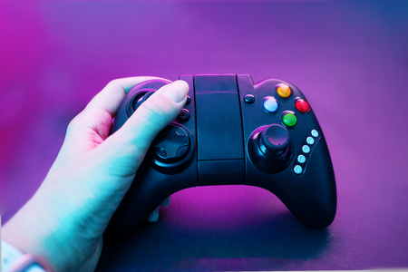 Hand with gamepad on violet tableの写真素材