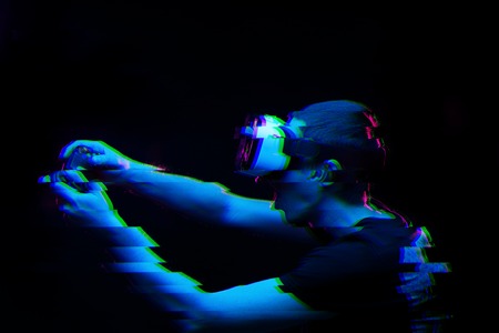 Man with virtual reality headset is playing game. Image with glitch effect.の写真素材