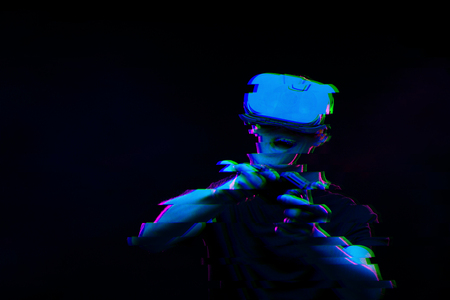 Man with virtual reality headset is playing game. Image with glitch effect.の写真素材