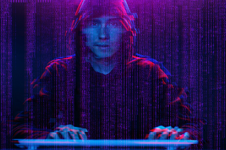 Hacker working with computer in dark room with digital interface around. Image with glitch effect.の写真素材