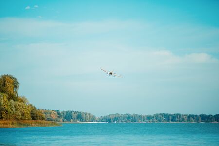 Autumn forest, flying plane over lake