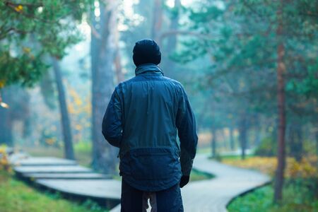 Photo from back of standing athlete in autumn parkの写真素材