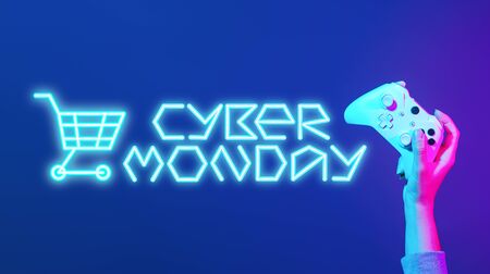 Hand holding joystick on blue background with blue inscription.の写真素材