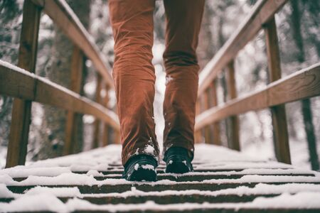 Man walking on wooden snowy bridge on winterの写真素材