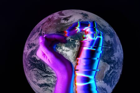 Heart shaped by the hands of man and robot against background of Earth.の写真素材