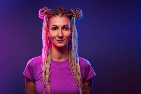 Young woman looking at camera in neon light