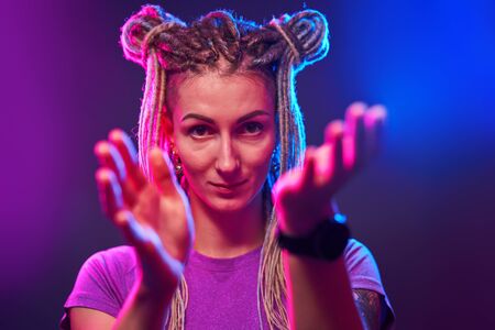 Happy girl looking at camera in neon lightの写真素材