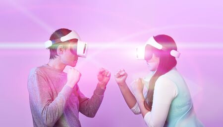 Couple with virtual reality headset are playing game and fighting. Concept of virtual reality,...