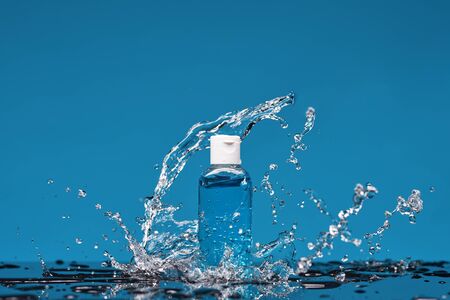 Bottle of antiseptic gel in splashes of water. Concept of washing hand, hygiene and prevention measures from the Covid-19 Corona virus.の写真素材