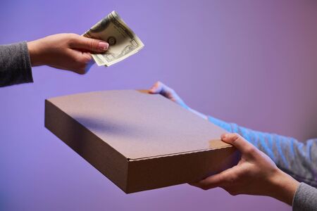 Two hands with cardboard box and dollar .