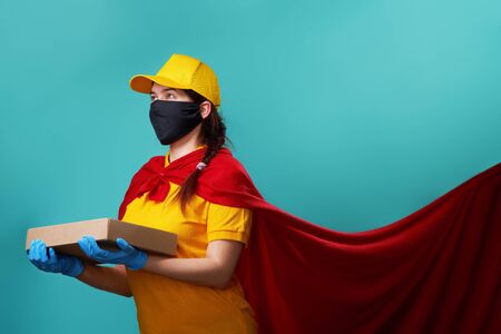 Courier is wearing urgical face mask in superhero cloak.の写真素材