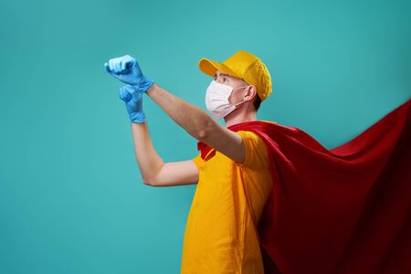 Courier is wearing in superhero cloak and protected face mask.の写真素材