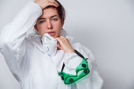 Doctor is taking off PPE - costume, gloves and respirator mask.の写真素材