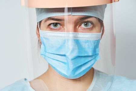 Doctor is wearing medical costume, mask and visor.の写真素材