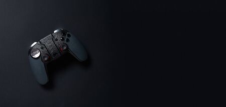 Black gamepad on black background. Gamer concept.