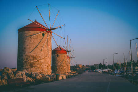 Rhodes, Greece - July 2019: Windmills in the portのeditorial素材