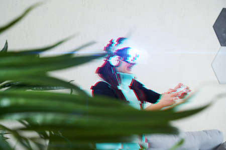 Woman with virtual reality headset is playing game. Image with glitch effect.