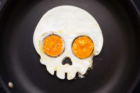 Fried eggs in the shape of a skull. Halloween breakfast.の写真素材