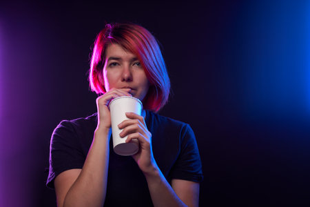 Gamer woman is drinking cola. Concept of virtual reality, games, entertainment and communication.の写真素材
