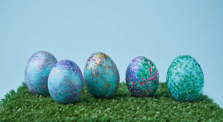 Blue painted eggs with bright shiny gliter on grassの写真素材